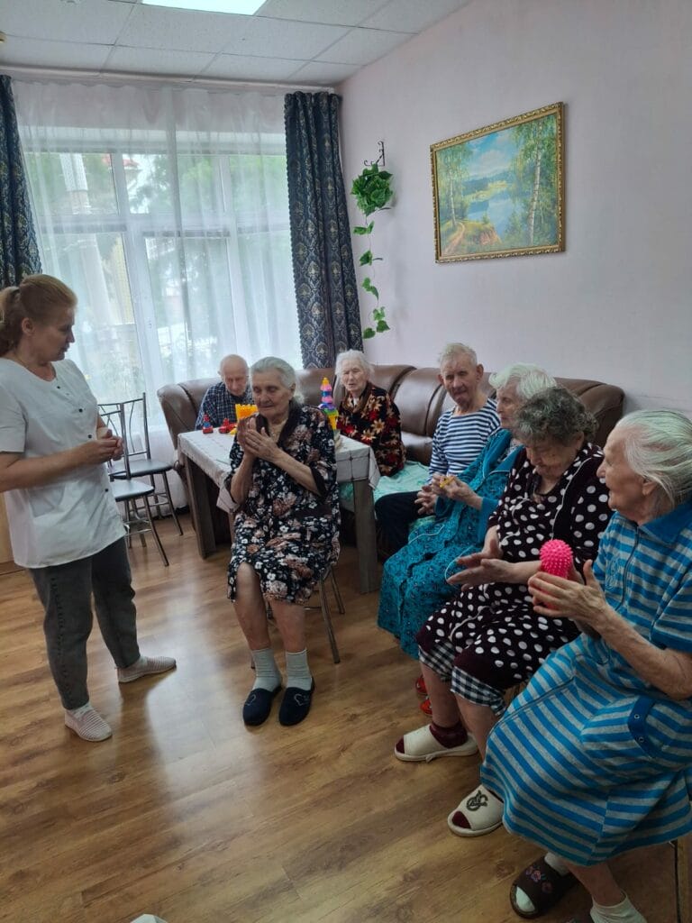 Групповое занятие пожилых людей под присмотром инструктора