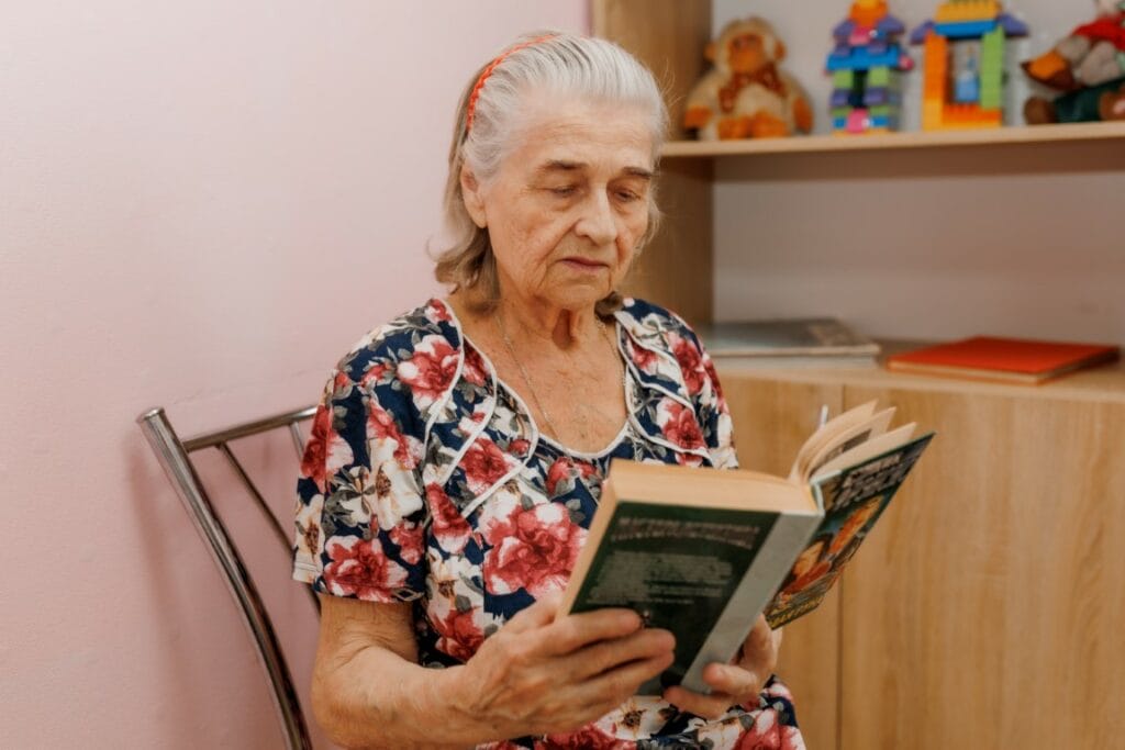 Пожилая женщина читает книгу